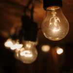 Lampadine accese in fila che rappresentano il consumo di energia elettrica e gas