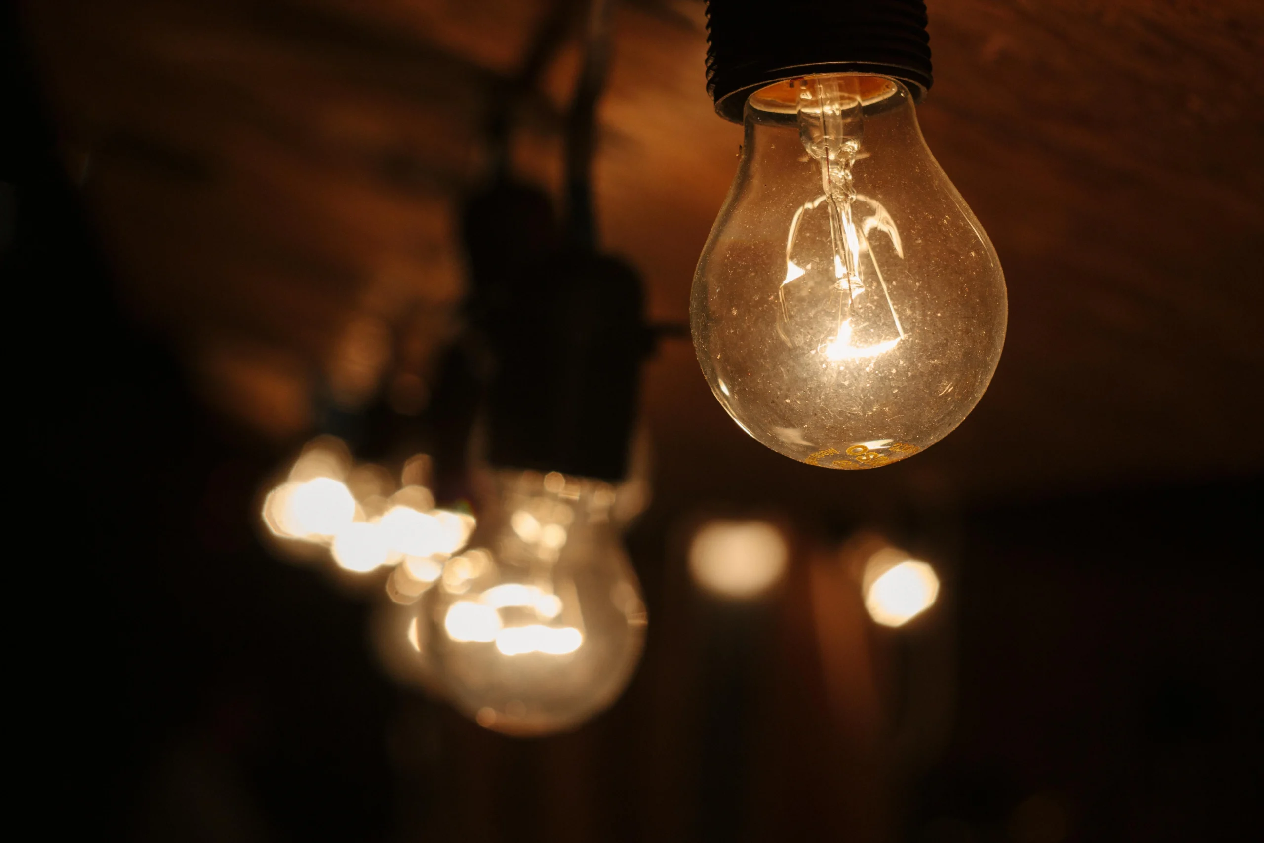 Lampadine accese in fila che rappresentano il consumo di energia elettrica e gas
